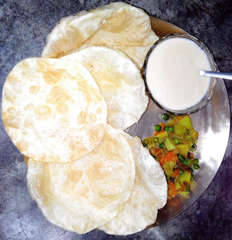 Luchi served with Aloo-sabzi and curd